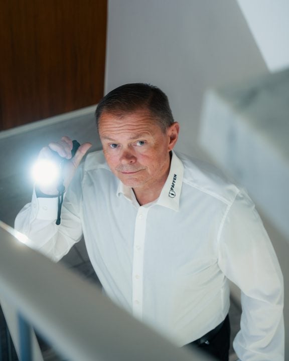 Sicherheitsmitarbeiter mit Taschenlampe in einem Treppenhaus