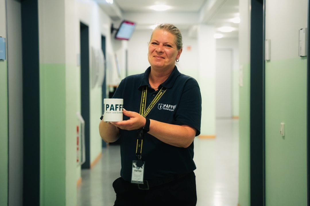 Sicherheitsmitarbeiterin lacht freundlich in die Kamera